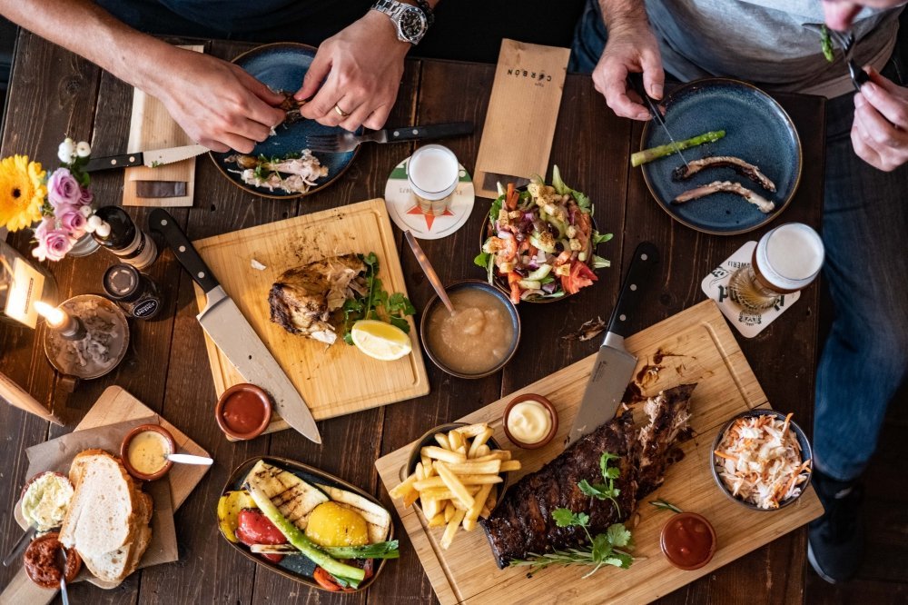 Gedekte tafel vol planken met vlees, ribs, brood en bijgerechten om te delen